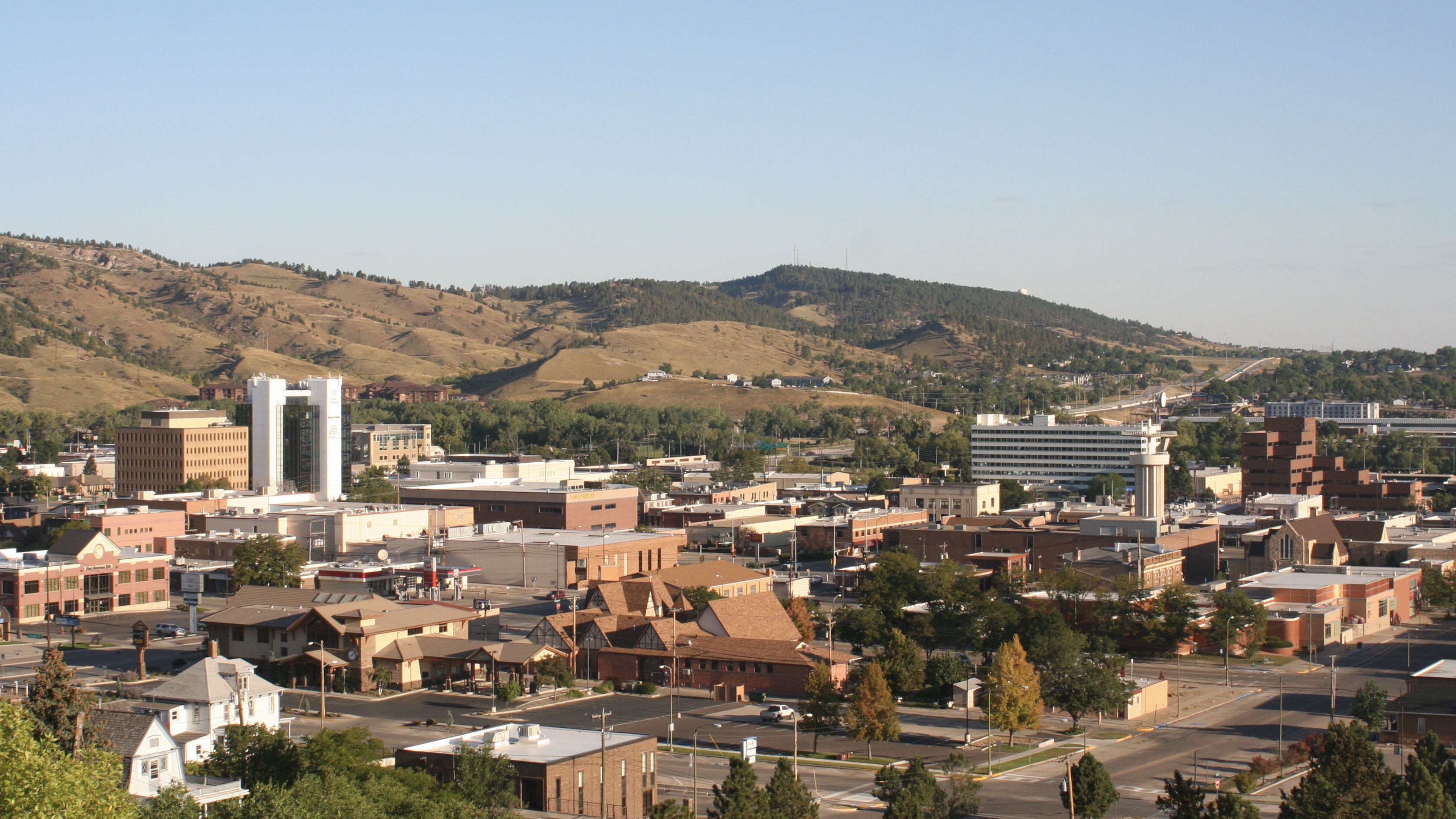 Rapid City is the second most populous city in South Dakota after Sioux Falls and the county seat of Pennington County. Named after Rapid Creek, where the settlement developed, it is in western South Dakota, on the Black Hills' eastern slope. The population was 74,703 as of the 2020 census.Known as the "Gateway to the Black Hills" and the "City of Presidents" because of the life-size bronze president statues downtown, Rapid City is split by a low mountain ridge that divides the city's western and eastern parts, called ‘The Gap.’ Ellsworth Air Force Base is on the city's outskirts. Camp Rapid, part of the South Dakota Army National Guard, is in the city's western part.
Rapid City is home to such attractions as Art Alley, Dinosaur Park, the City of Presidents walking tour, Chapel in the Hills, Storybook Island, and Main Street Square. The historic "Old West" town of Deadwood is nearby. In the neighboring Black Hills are the tourist attractions of Mount Rushmore, the Crazy Horse Memorial, Custer State Park, Wind Cave National Park, Jewel Cave National Monument, and the museum at the Black Hills Institute of Geological Research. To the city's east is Badlands National Park.