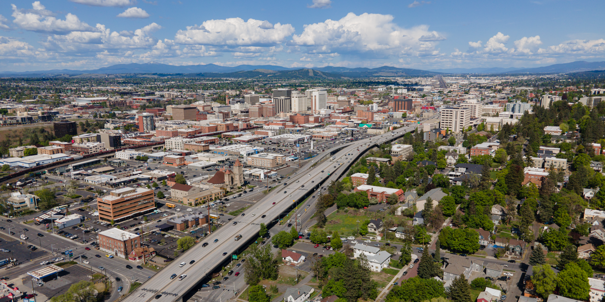 Spokane (  spoh-KAN) is the most populous city in and seat of government of Spokane County Washington, United States. It is in eastern Washington, along the Spokane River, adjacent to the Selkirk Mountains, and west of the Rocky Mountain foothills, 92 miles (148 km) south of the Canadian border, 18 miles (30 km) west of the Washington–Idaho border, and 279 miles (449 km) east of Seattle, along Interstate 90.
Spokane is the economic and cultural center of the Spokane metropolitan area, the Spokane–Coeur d'Alene combined statistical area, and the Inland Northwest. It is known as the birthplace of Father's Day, and locally by the nickname of "Lilac City". Officially, Spokane goes by the nickname of Hooptown USA, due to Spokane annually hosting Spokane Hoopfest, the world's largest basketball tournament. The city and the wider Inland Northwest area are served by Spokane International Airport, 5 miles (8 km) west of Downtown Spokane, which is located near another airfield at Fairchild Air Force Base. According to the 2010 census, Spokane had a population of 208,916, making it the second-most populous city in Washington, and the 97th-largest city in the United States. At the 2020 census, Spokane's population was 228,989. A 2022 estimate sets the population of the Spokane Metropolitan Area at 597,919.The first people to live in the area, the Spokane tribe (their name meaning "children of the sun" in Salishan), lived off plentiful game. David Thompson explored the area with the westward expansion and establishment of the North West Company's Spokane House in 1810. This trading post was the first long-term European settlement in Washington. Completion of the Northern Pacific Railway in 1881 brought many settlers from America to the Spokane area. The same year it was officially incorporated as a city under the name of Spokane Falls (it was re-incorporated under its current name ten years later). In the late 19th century, gold and silver were discovered in the Inland Northwest. The local economy depended on mining, timber, and agriculture until the 1980s. Spokane hosted the first environmentally themed World's fair at Expo '74.
Many of the downtown area's older Romanesque Revival-style buildings were designed by architect Kirtland Kelsey Cutter after the Great Fire of 1889. The city is also home to the Riverfront and Manito parks, the Smithsonian-affiliated Northwest Museum of Arts and Culture, the Davenport Hotel, and the Fox and Bing Crosby theaters.
The Cathedral of Our Lady of Lourdes is the seat of the Roman Catholic Diocese of Spokane, and the Cathedral of St. John the Evangelist serves as that of the Episcopal Diocese of Spokane. The Spokane Washington Temple in the east of the county serves the Church of Jesus Christ of Latter-day Saints. Gonzaga University was established in 1887 by the Jesuits, and the private Presbyterian Whitworth University was founded three years later and moved to north Spokane in 1914.
In sports, the region's professional and semi-professional sports teams include the Spokane Indians in Minor League Baseball and Spokane Chiefs in junior ice hockey. The Gonzaga Bulldogs collegiate basketball team competes at the Division I level. As of 2010, Spokane's major daily newspaper, The Spokesman-Review, had a daily circulation of over 76,000.